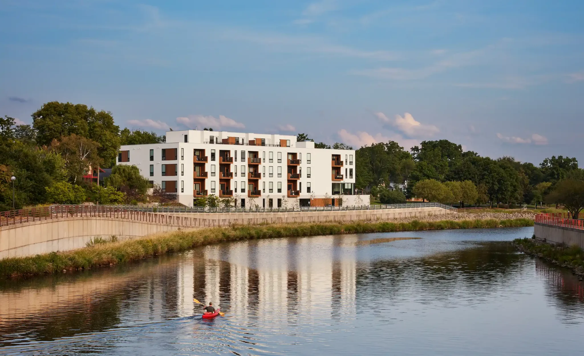 A kayaker on the Zumbro River beside the Lofts at Mayo Park in Rochester, MN