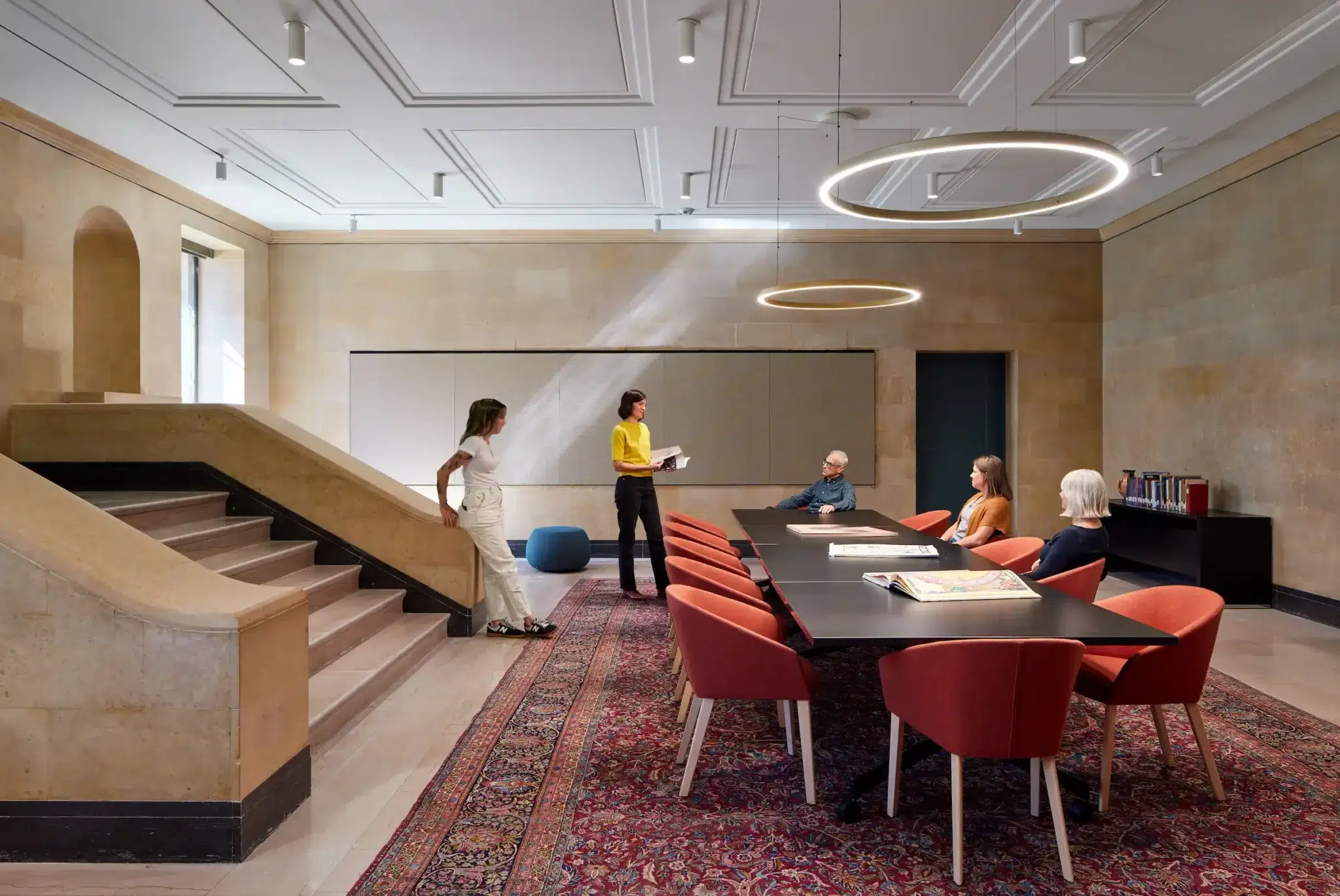 Professionals at a table in an upscale marble room with circular LED lamps