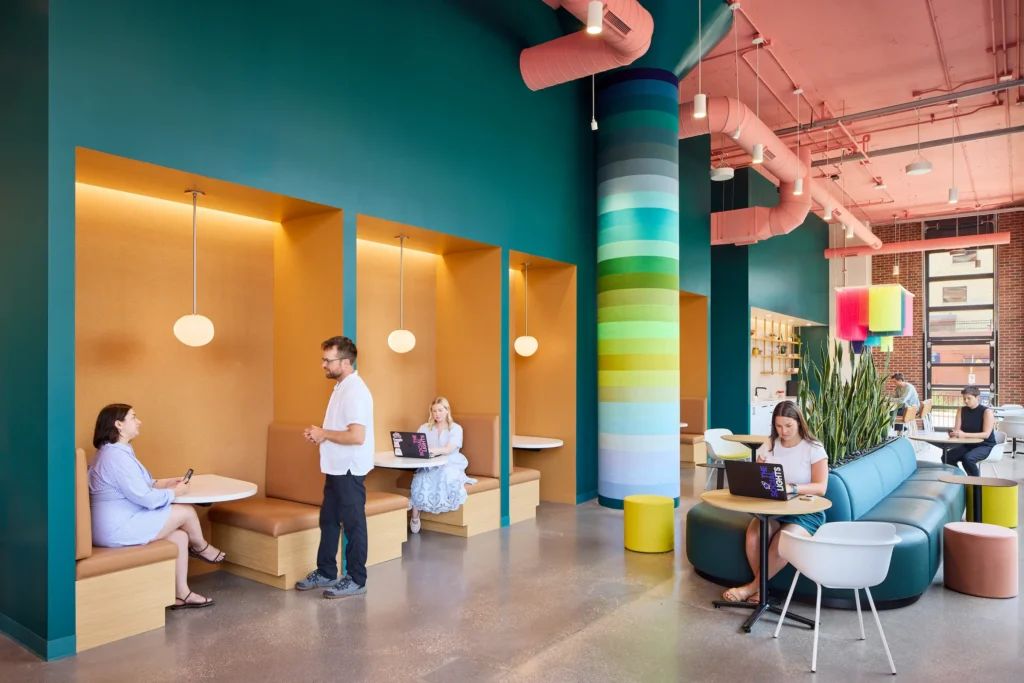 People working the colorful The Social Lights Office with yarn-wrapped columns