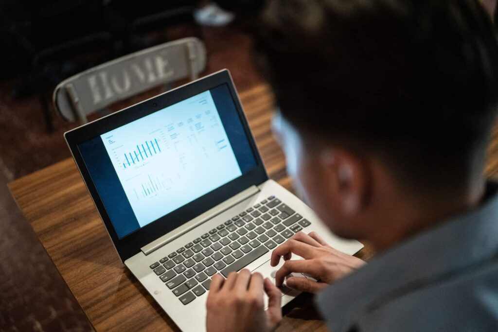 Young-male-employee-working-on-his-laptop-and-looking-at-corporate-real-estate-data