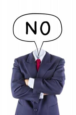 A person in a suit with crossed arms has a speech bubble saying "NO" where their head should be.