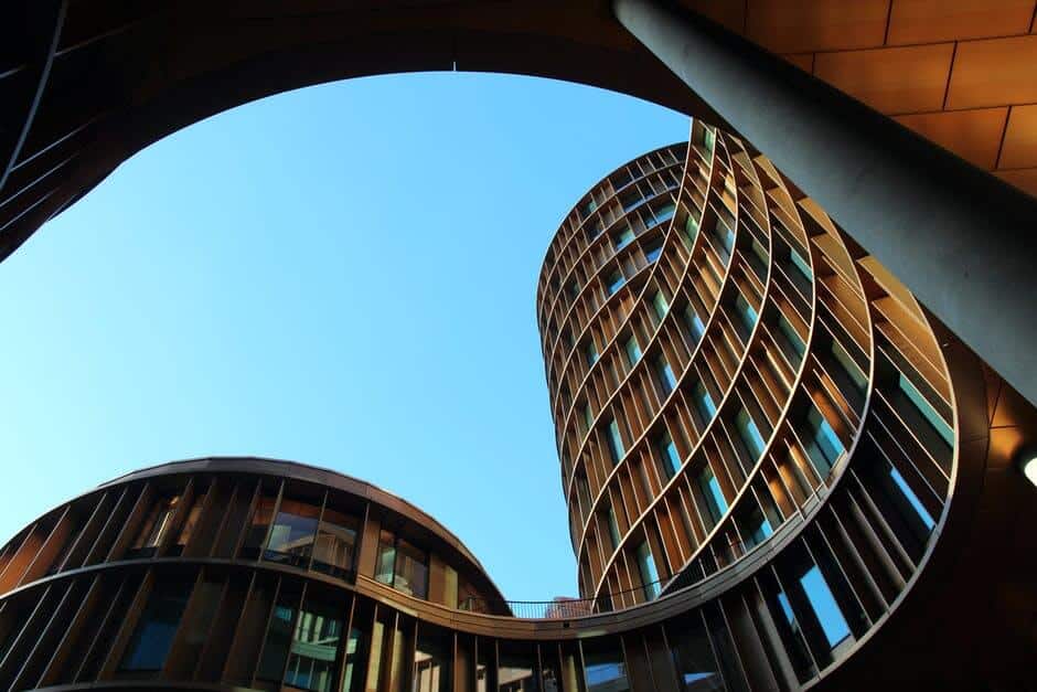 Curved, modern buildings with circular pattern and glass windows against a clear blue sky.