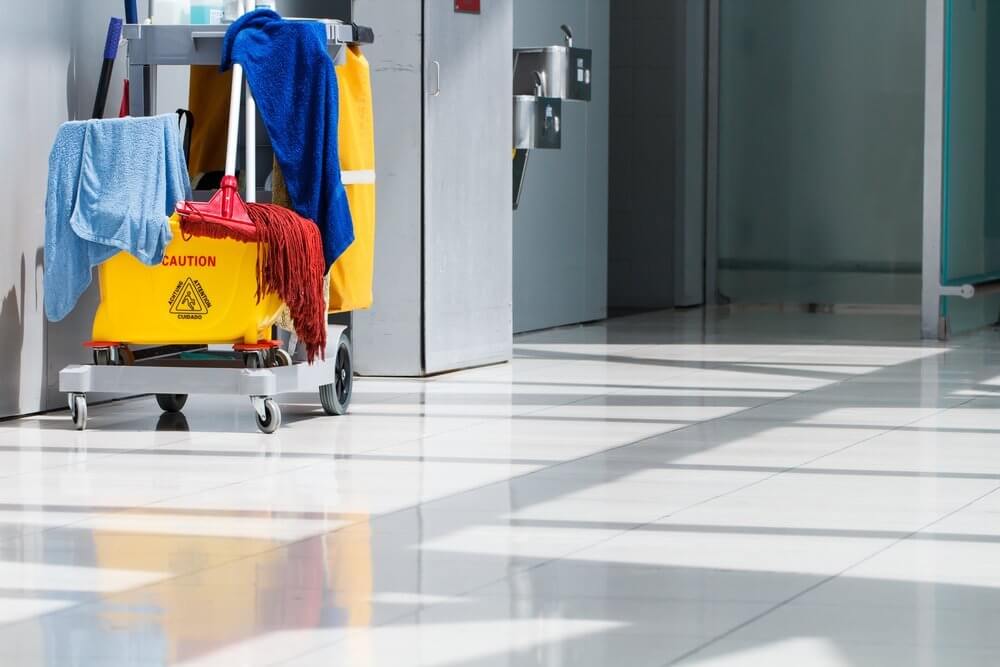 Mop bucket and cleaning supplies in hallway