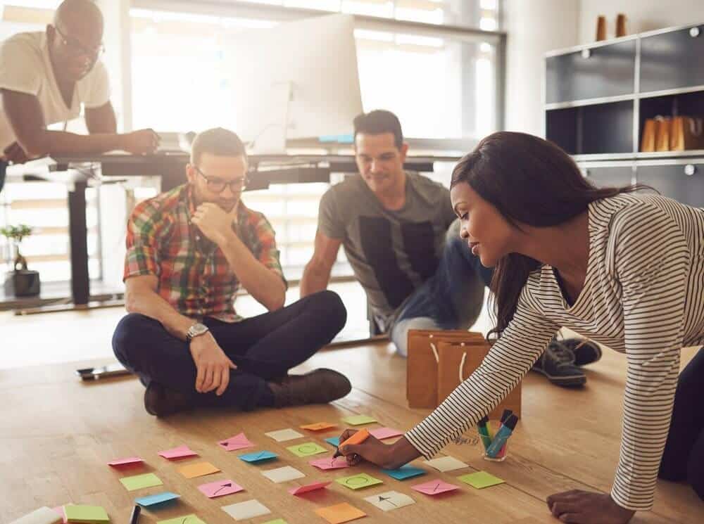 employees sharing ideas on floor during meeting