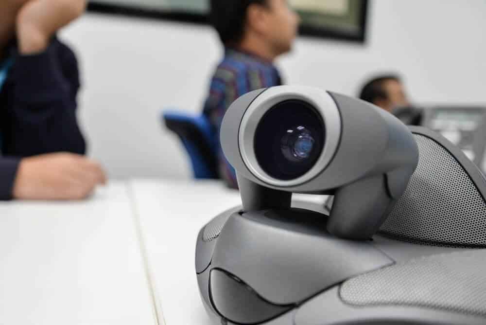 workers in conference room on video call