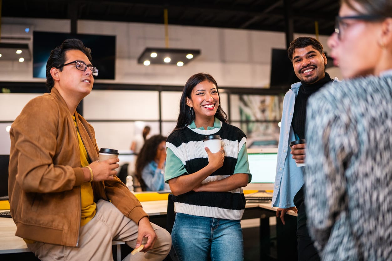 A group of people chat in a modern workplace