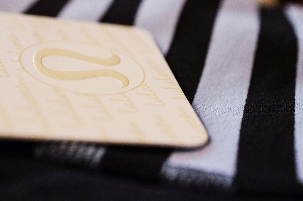 Close-up of a patterned card with a logo placed on fabric with black and white stripes.