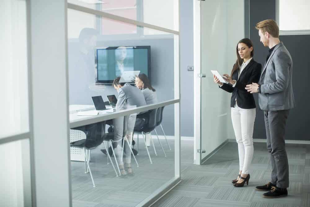 Young professionals using technology to book a room in office