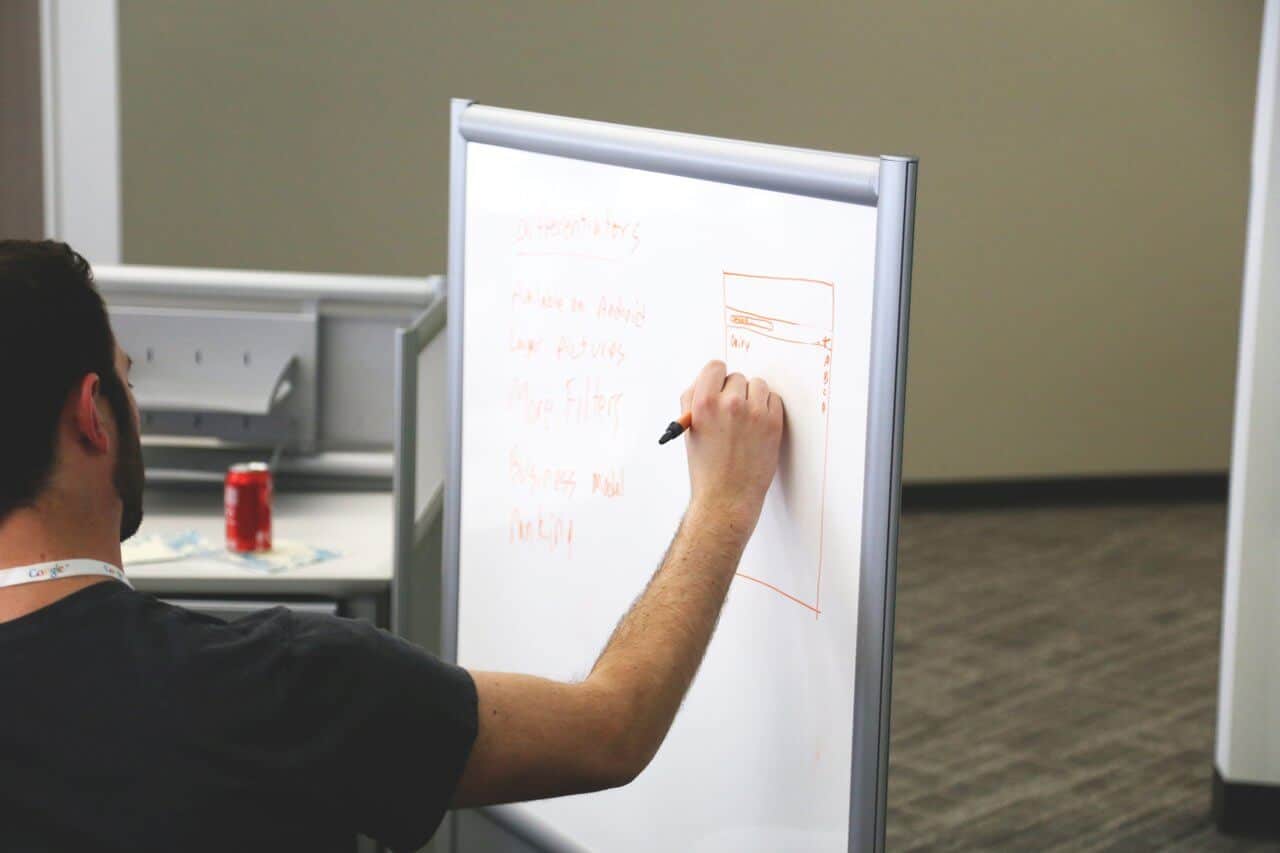 employee writing on a whiteboard