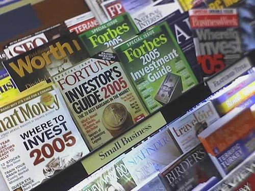 Magazines on a rack featuring investment and finance guides from 2005, including Forbes and Fortune.