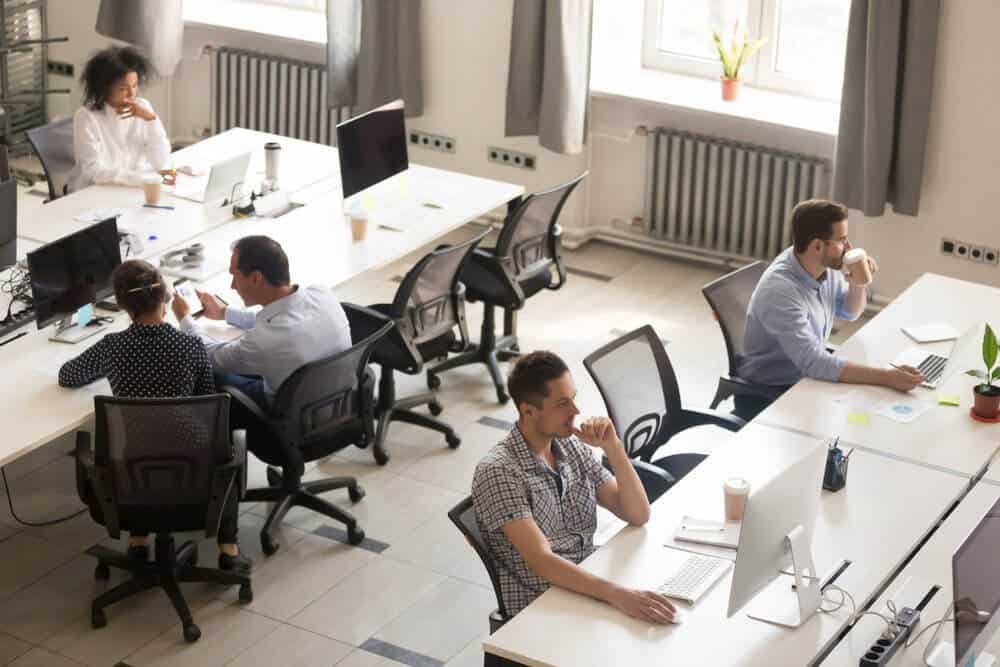 Colleagues collaborating and working on computers in office space Colleagues collaborating and working on computers in office space