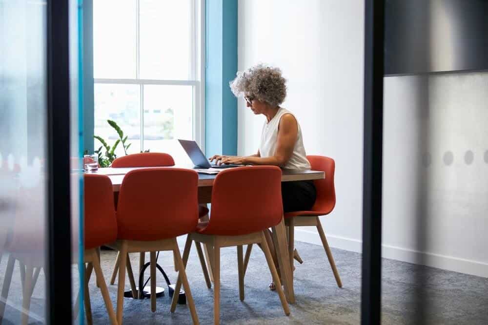 Mature woman preparing for training in office boardroom Mature woman preparing for training in office boardroom