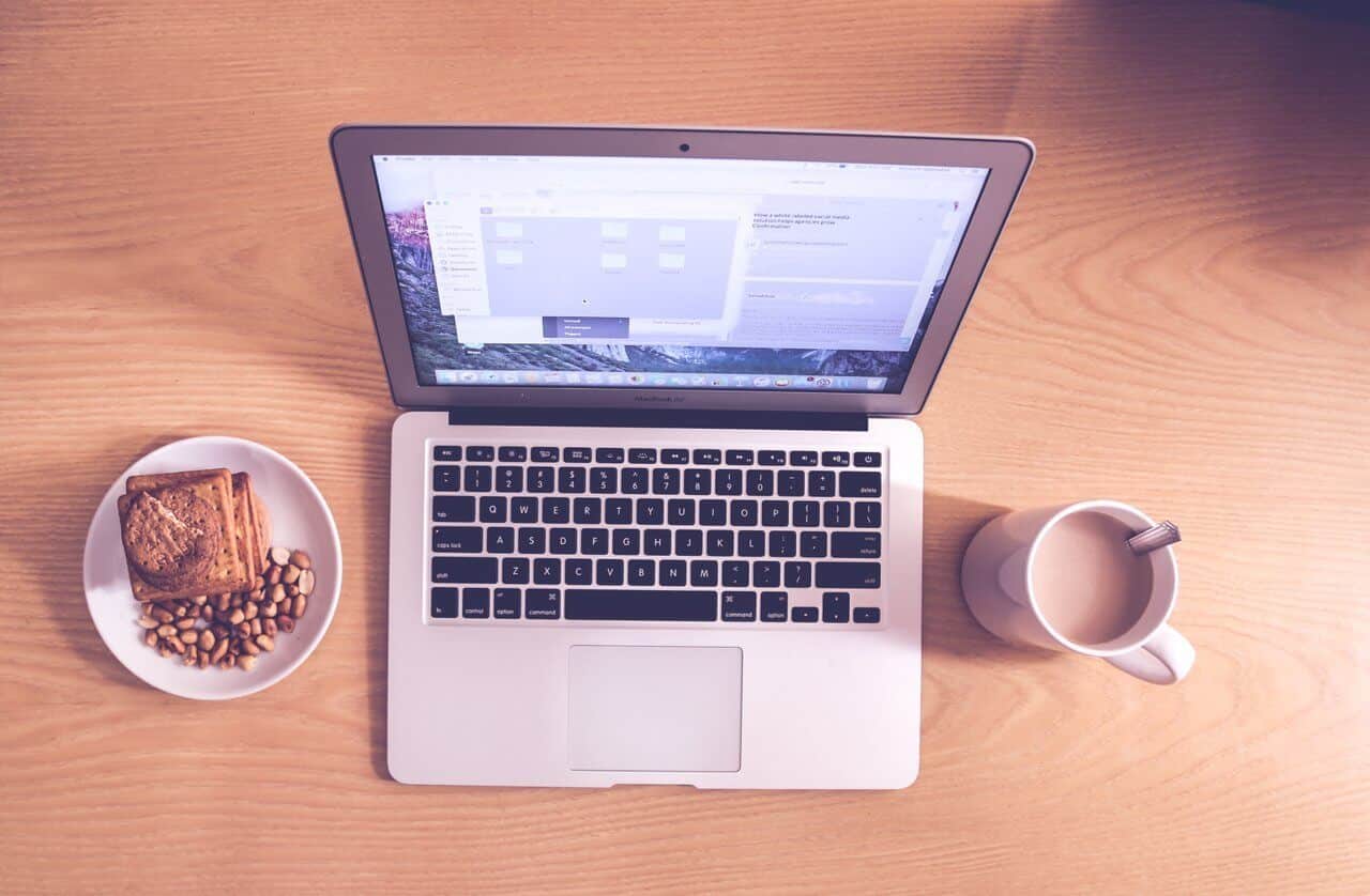 open laptop with coffee and snacks