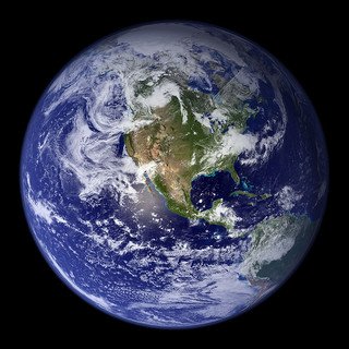 View of Earth from space showing continents, oceans, and swirling clouds.