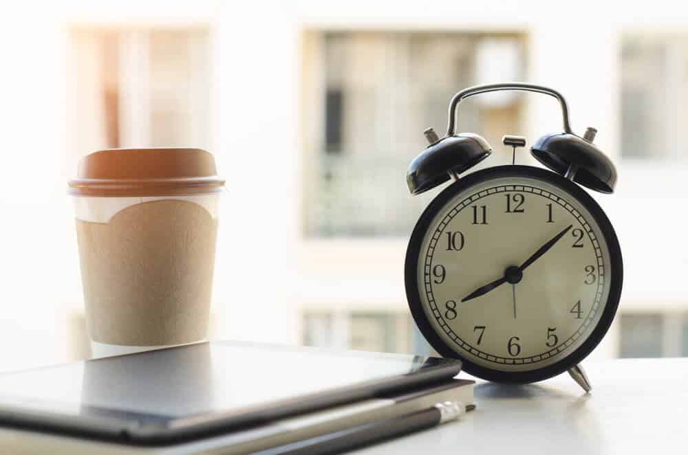 clock, coffee and tablet on table clock, coffee and tablet on table