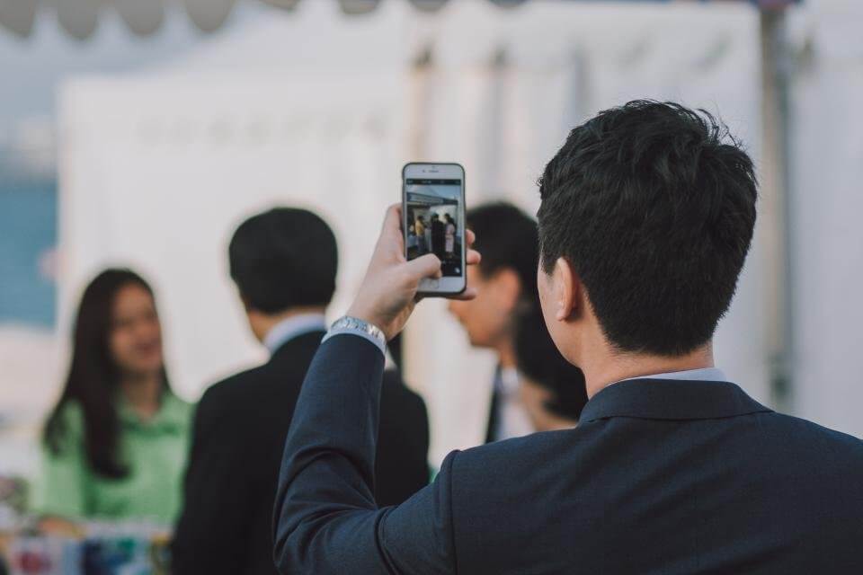 Man Taking Video in Office With iPhone