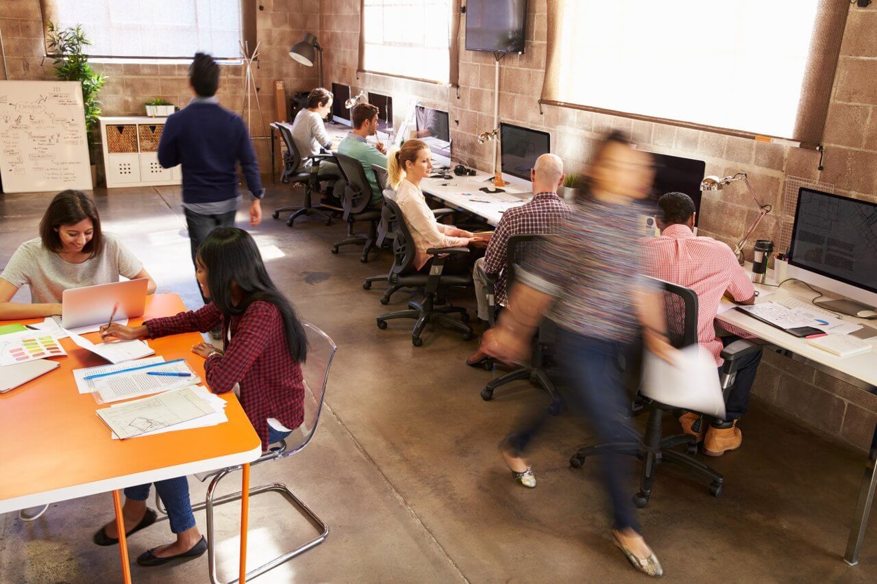 Modern office with people working at laptops and table